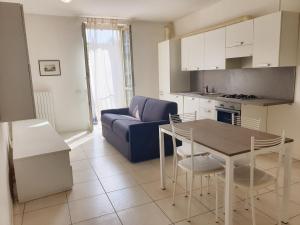 ein Wohnzimmer mit einem Tisch und einem blauen Sofa in der Unterkunft Apparthotel CASA IDEALE LECCO in Lecco