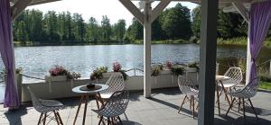 a patio with tables and chairs next to a lake at Dolina Witówki in Mrozy