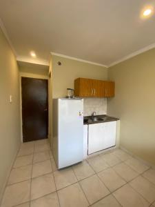 uma cozinha com um frigorífico branco e um lavatório em Los Girasoles Villa Sarita Posadas - 1B em Posadas