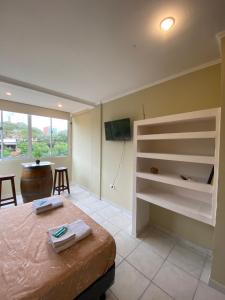 um quarto com uma cama, uma televisão e uma mesa em Los Girasoles Villa Sarita Posadas - 1B em Posadas