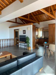 ein Wohnzimmer mit einer schwarzen Couch und einem Tisch in der Unterkunft casa panorâmica bela vista in Angra do Heroísmo