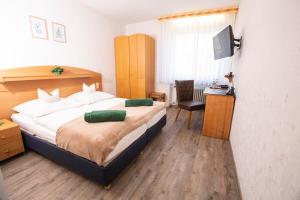 a bedroom with a large bed and a chair at Hotel-Pension Haus Holtdirk in Lippstadt