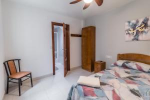 um quarto com uma cama e uma cadeira em Hostal - Restaurante La Buena Villa by Vivere Stays em Villalonquéjar