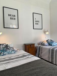 2 Betten in einem Zimmer mit 2 Bildern an der Wand in der Unterkunft Le gîte du familistère in Guise