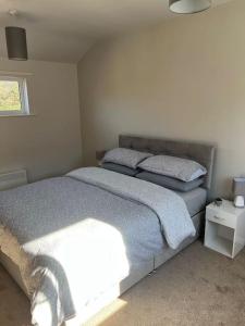 1 dormitorio con 2 camas y ventana en Lake District Coastal cottage, en Seascale