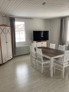 une salle à manger avec une table et des chaises blanches dans l'établissement Ferienwohnung mit 125qm am Rande der Fußgängerzone in Sigmaringen, à Sigmaringen