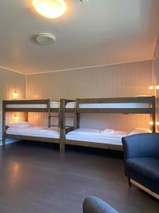 Fjordly Ungdomssenter في Bryggja: سريرين بطابقين في غرفة مع أريكة