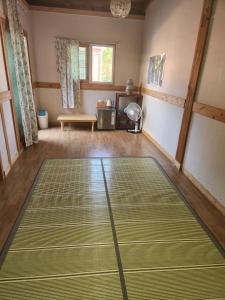 全州的住宿－美麗之家民宿，客厅的地板上设有绿色垫子