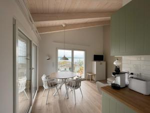 eine Küche und ein Esszimmer mit einem Tisch und Stühlen in der Unterkunft HAUS IM SCHILF 2 - Ferienwohnungen am Hainer See bei Leipzig in Neukieritzsch