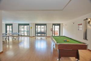 a room with a pool table and two tables at Apartagal-Costa Reinante Spa in Barreiros