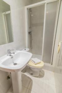 uma casa de banho com um lavatório, um WC e um chuveiro em Hostal - Restaurante La Buena Villa by Vivere Stays em Villalonquéjar