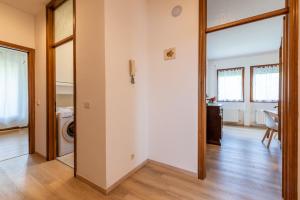 a hallway with a door leading to a laundry room at Grazioso appartamento ai piedi delle Dolomiti - SELF CHECK-IN in Cesiomaggiore