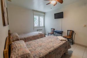 1 dormitorio con 2 camas y TV de pantalla plana en Hostal - Restaurante La Buena Villa by Vivere Stays en Villalonquéjar