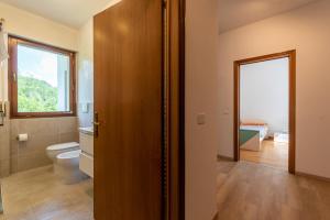 a bathroom with a toilet and a window at Grazioso appartamento ai piedi delle Dolomiti - SELF CHECK-IN in Cesiomaggiore