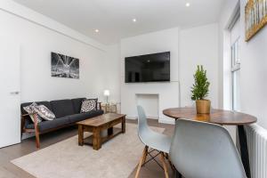 een woonkamer met een bank en een tafel bij Stunning Modern two bedroom flat near Notting hill Gate in Londen