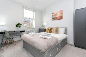 een slaapkamer met een bed met handdoeken erop bij Stunning Modern two bedroom flat near Notting hill Gate in Londen