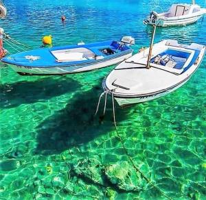 two boats are docked in the clear water at Seafront apartment Marina2 in Jelsa