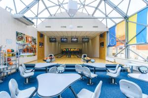 una sala da bowling con tavoli e sedie e una pista da bowling di Sovinyon Resort a Odessa
