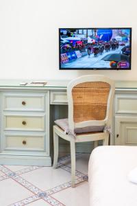 - une chambre avec un bureau, une télévision et une chaise dans l'établissement B&B Marcantonio - Ischia Ponte, à Ischia
