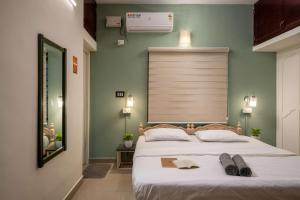 Un dormitorio con una cama grande con dos zapatos. en Zostel Kochi, Fort Kochi en Kochi