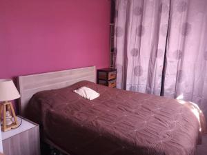 ein Schlafzimmer mit einem Bett und einer lila Wand in der Unterkunft Villa contemporaine à 10mn des plages in Lattes
