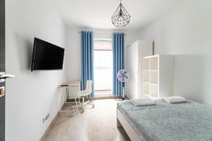 um quarto com uma cama, uma secretária e uma televisão em Apartament 10. Piętro - ACCO RENT em Gdansk