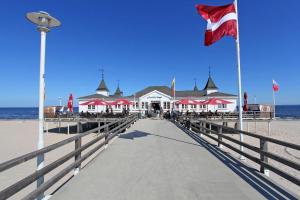 アールベックにあるFerienwohnungen Ahlbeck USE 2270の旗の建つ海岸の桟橋