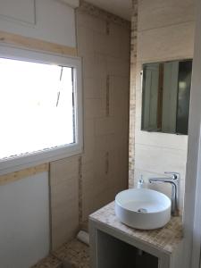 baño con lavabo y ventana en Le gîte du familistère, en Guise