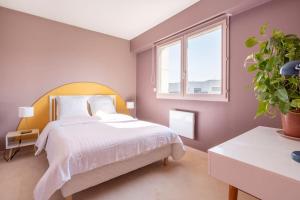 una camera con un letto bianco e una pianta in vaso di City Escape a Le Bourget