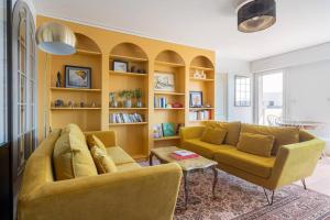 a living room with a yellow couch and a table at City Escape in Le Bourget