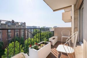 un balcón con 2 sillas y una planta en City Escape, en Le Bourget