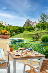 a table on a balcony with a view of a castle at B&B Marcantonio - Ischia Ponte in Ischia