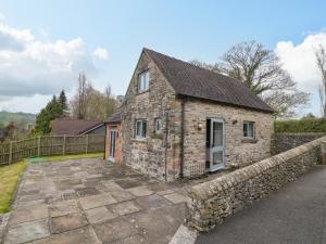 una antigua casa de piedra con entrada de piedra en Postbox Cottage en Ashbourne