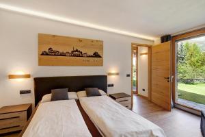 een slaapkamer met 2 bedden en een groot raam bij Chalet Monteneve Appartamento Neve in Livigno