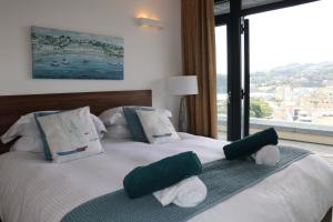 um quarto com uma cama com almofadas verdes e brancas em Riviera Apartments - Five Stylish Penthouse Apartments with Unrivalled Sea Views of Teignmouth, Shaldon, The Jurassic Coastline & The Teign Estuary em Teignmouth