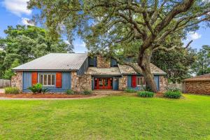 a house with a tree in front of a yard at 4527 Whisper Way in Pensacola
