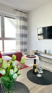 a living room with a table with a vase of flowers at Apartament Red Mielno in Mielno