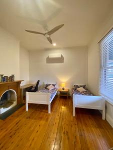 a living room with two beds and a ceiling fan at Somerby! in Albury