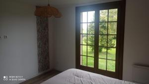 a bedroom with a bed and a large window at LA BELLA 12-Appartement rez de chaussée 90m² in Bordeaux-Saint-Clair