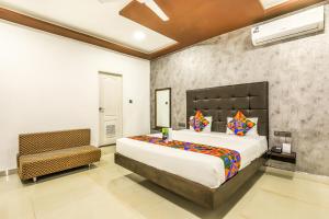 a bedroom with a large bed and a chair at FabHotel Prime Sea Shore Resort in Calangute