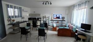 Il comprend un salon avec des chaises et une table ainsi qu'une cuisine. dans l'établissement Go Island, à Praia a Mare