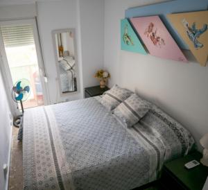 ein Schlafzimmer mit einem Bett und einige Bilder an der Wand in der Unterkunft Apartamento Beach View in Torremolinos