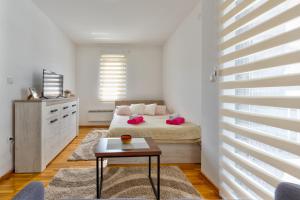 Un dormitorio con una cama y una mesa. en Mount Inn Studio, en Zlatibor