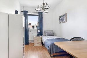 ein kleines Schlafzimmer mit einem Bett und einem Tisch in der Unterkunft Guestly Homes - 3BR City Charm in Piteå