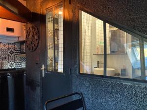 puerta a un baño con lavabo y espejo en LE VICTORIA, en Besançon 30 fotos más