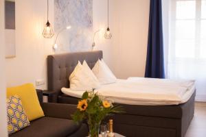 łóżko i kanapa w małym pokoju w obiekcie Hotel Zum Goldenen Hirschen w mieście Freistadt
