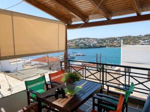 a table and chairs on a balcony with a view of the water at Maria's guesthouse in Batsi