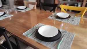 Una mesa de madera con dos platos blancos y un sombrero negro. en Casa FotoStudi37, en Deltebre 27 fotos más