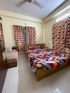 a bedroom with a bed and a couch and curtains at Your Home Away B&B in Sylhet