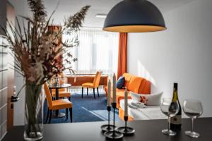 ACHAT Hotel Dresden Altstadt في درسدن: غرفة معيشة مع أريكة وطاولة مع إناء من الزهور